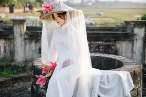 Discover the captivating grace of a Vietnamese woman in a flowing white Ao Dai and traditional conical hat-9