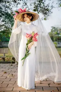 Discover the captivating grace of a Vietnamese woman in a flowing white Ao Dai and traditional conical hat-24