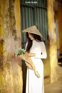 Captivating Beauty: Vietnamese Girl in White Ao Dai with Delicate Daisies.-3