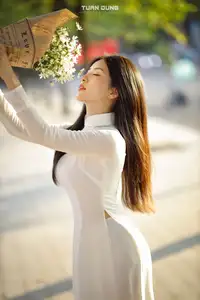 Captivating Beauty: Vietnamese Girl in White Ao Dai with Delicate Daisies.-1