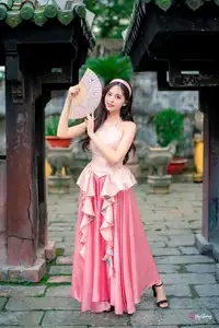 Graceful Woman in Pink Dress Amidst Ancient Heritage Charm 1000025280-3