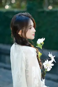 Pure Charm: White-Dressed Girl Winking Playfully with White Flowers 1000024585-4