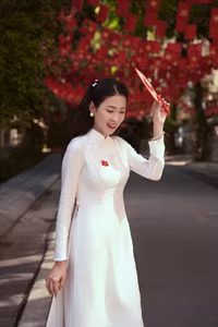 VGU No.110: Elegant White Ao Dai Amidst Red Flags, Celebrating Vietnamese Grace and Patriotism.-1