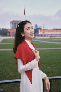 VGU No.110: Elegant White Ao Dai Amidst Red Flags, Celebrating Vietnamese Grace and Patriotism.-6