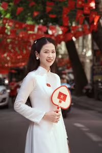 VGU No.110: Elegant White Ao Dai Amidst Red Flags, Celebrating Vietnamese Grace and Patriotism.-0