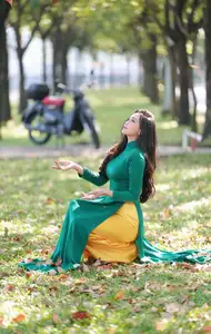 Vietnamese Grace: Elegant Woman in Green Ao Dai with Pink Lotus Flower 1000025232-11
