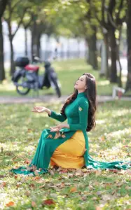 Vietnamese Grace: Elegant Woman in Green Ao Dai with Pink Lotus Flower 1000025232-2