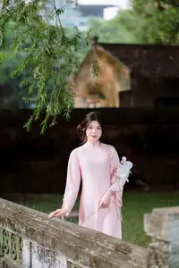 Elegant Vietnamese Beauty: Young Woman Gracefully Posing in Pink Ao Dai with White Orchids 1000026874-8