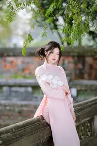 Elegant Vietnamese Beauty: Young Woman Gracefully Posing in Pink Ao Dai with White Orchids 1000026874-9