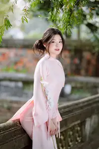Elegant Vietnamese Beauty: Young Woman Gracefully Posing in Pink Ao Dai with White Orchids 1000026874-2